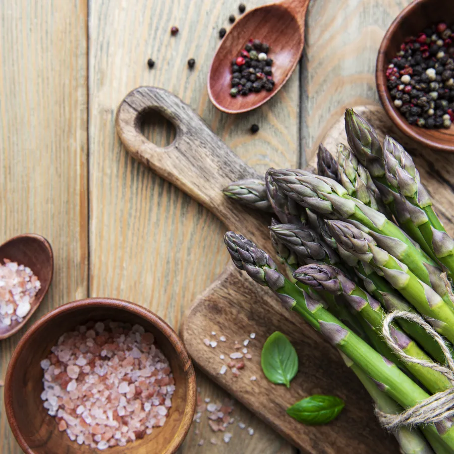 Cuisson des asperges crues sur une table en bois