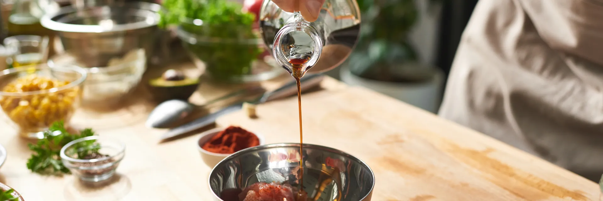 Cuisinier qui verse du vinaigre dans un saladier 