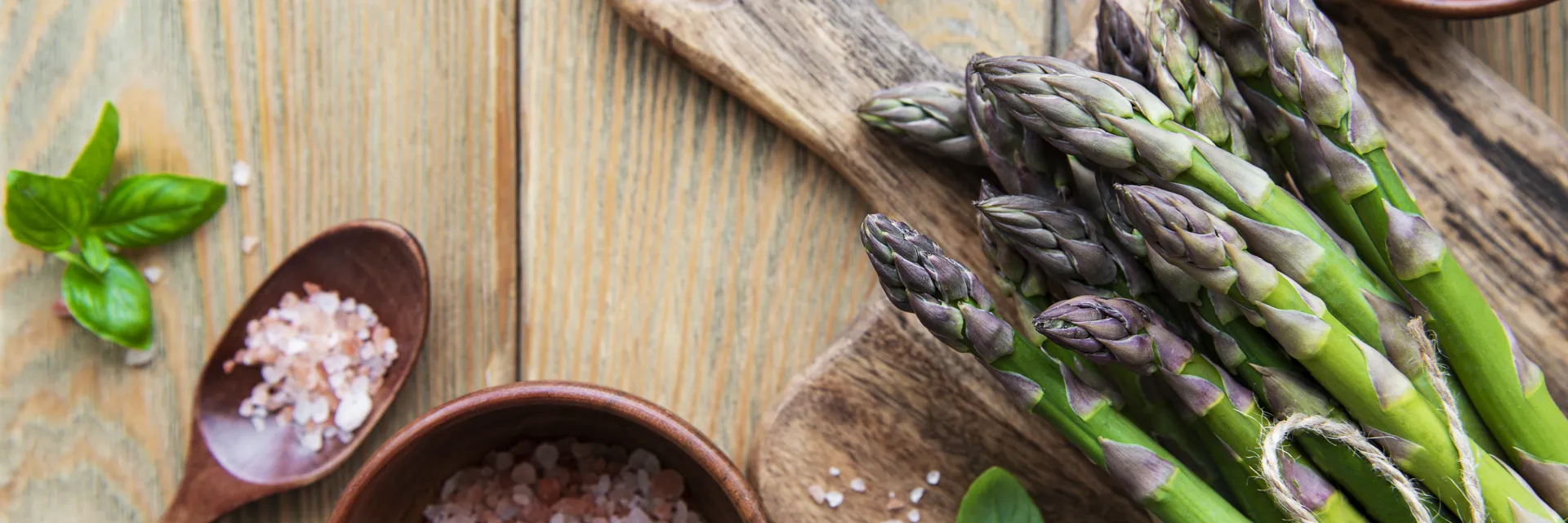 Cuisson des asperges crues sur une table en bois