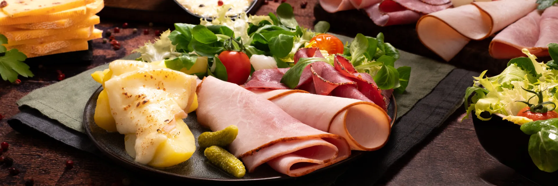 Assiette raclette avec fromage, charcuterie et salade 