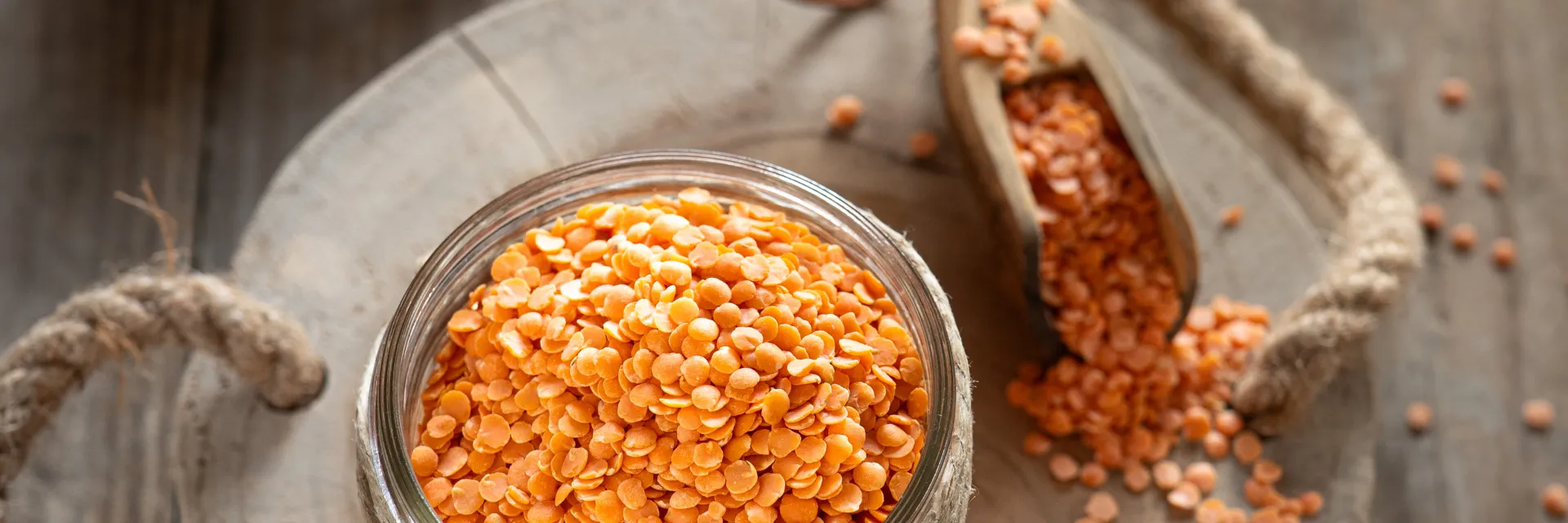 Pot de lentilles corail sur une planche en bois
