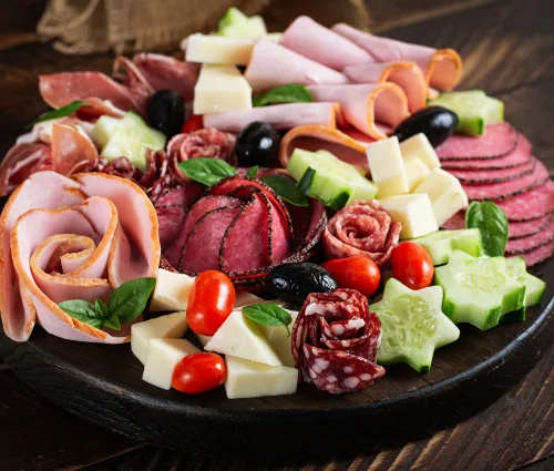 Assiette de charcuterie, fromages et légumes sur une table en bois 